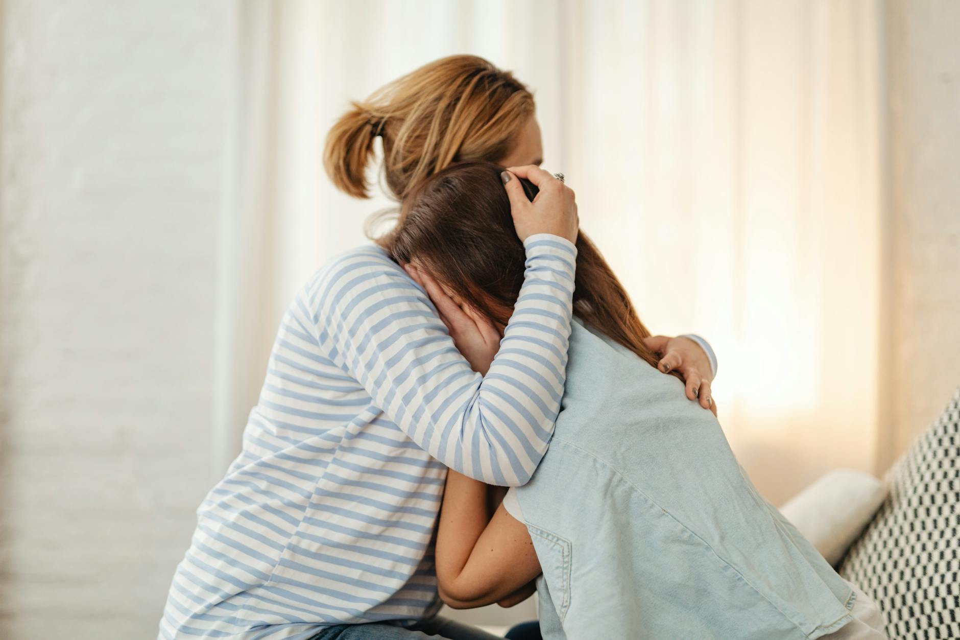 mother comforting crying daughter